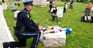 OPP Sgt. Kerry Schmidt joins protesters taking a knee. at Wednesday's protest.